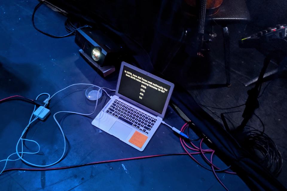 Photo of a laptop and projector backstage