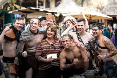 A group of men in barbarian costume with a woman smiling